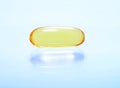 Shiny yellow vitamin omega3 fish oil capsule background. Royalty Free Stock Photo