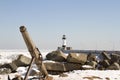 Ship anchor on rocky shore along pier with lighthouse in Duluth, Minnesota Royalty Free Stock Photo