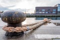 Ship is attached with a thick rope to a bollard in the harbour Royalty Free Stock Photo