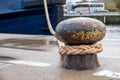 Ship is attached with a thick rope to a bollard in the harbour Royalty Free Stock Photo