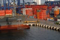 A ship being unloaded, Trucks, Containers, and Cranes