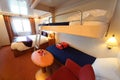 Ship cabin with window, bed and two children beds Royalty Free Stock Photo