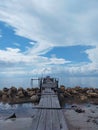 a ship crossing on the beach wood and around it surrounded by large rocks with beautiful views of blue clouds perfecting