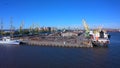 Ship docks off Kanonersky Island. Industrial port with water barges and transport tugs