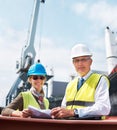 Ship engineer team planning in a meeting on the dock talking about paper work, cargo and shipping. Portrait of happy and Royalty Free Stock Photo