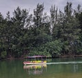 A ship gracefully glides across the tranquil lake, framed by a breathtaking backdrop of lush green hills and a vibrant, colorful.