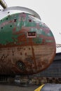 Ship on blocks in drydock. Worker inspecting bow thruster. Hull spot painted with red primer Royalty Free Stock Photo