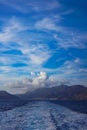 On the ship after leaving the port of Pothia, Kalymnos. Stern waves, in the background the harbor and mountainous land. Formation Royalty Free Stock Photo