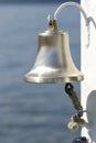 Ship metal bell with rope on a white hook Royalty Free Stock Photo