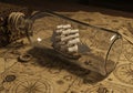 A ship model with multiple sails is enclosed in a clear glass bottle, resting on a table Royalty Free Stock Photo