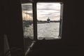 Ship moored to port seen through from inside the porthole of a ship Royalty Free Stock Photo