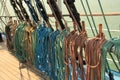 Ship multi-colored ropes on the rails amd wooden deck.