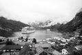 Ship in norwegian fjord on cloudy sky. Ocean liner in village harbor. Travel destination, tourism. Adventure, discovery Royalty Free Stock Photo