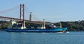 A ship pass under The 25th of April Bridge, Lisbon, Portugal Royalty Free Stock Photo