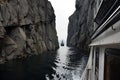 ship passing through narrow fjord channel, rock faces tight Royalty Free Stock Photo