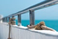 Ship railing with rope and blue sea Royalty Free Stock Photo