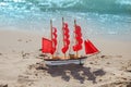 Ship with red sails on sea beach background. Travel, vacation and cruise concept