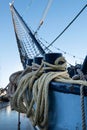 Ship\'s bow with jib boom and tightly knotted jib net, ropes twisted around the iron bollards Royalty Free Stock Photo