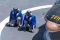 Ship`s crew ties down the Bell 212 helicopter of royal Thai navy on the flight deck of HTMS. Bhumibol Adulyadej