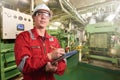 Ship`s mechanic near marine diesel generators on a merchant ship in the engine room Royalty Free Stock Photo