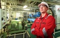 Ship`s mechanic near marine diesel generators on a merchant ship in the engine room