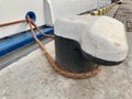 The ship`s rope is tied to a post in the dock. The ship is moored to the shore. The rope keeps the boat on the pier Royalty Free Stock Photo