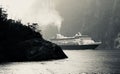 CRUISE SHIP NAVIGATES THE STEEP CLIFFS OF MILFORD SOUND NEW ZEALAND