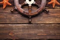 Ship`s steering wheel, shells and brown fishing net on wooden ta Royalty Free Stock Photo