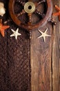 Ship`s steering wheel, starfish and fishing net on wooden table Royalty Free Stock Photo