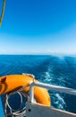 Ship`s stern, lifeline. Footprint on the water from the boat. Blue water and mountains on the horizon. Issyk-Kul, Kyrgyzstan Royalty Free Stock Photo