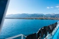 Ship`s stern, lifeline. Footprint on the water from the boat. Blue water and mountains on the horizon. Issyk-Kul, Kyrgyzstan Royalty Free Stock Photo