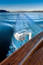 Ship`s wake and auxilliary light in the cool clear air of dawn, Alaska, USA.