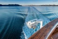 Ship`s wake and auxilliary light in the cool clear air of dawn, Alaska, USA.