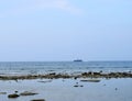 A Ship Sailing at Distance over Sea - Rocky Beach and Clear Sky - Natural Background - Laxmanpur, Neil Island, Andaman, India Royalty Free Stock Photo