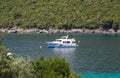 The ship sails the sea bay. The beautiful blue sea is surrounded by green forest. A wonderful place to rest and relax. Royalty Free Stock Photo