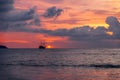 A ship at sea catches the sun against the sunset sky. Royalty Free Stock Photo