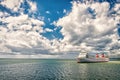 Ship in sea on cloudy blue sky. Seascape with ocean liner and clouds. Summer vacation, adventure and wanderlust concept Royalty Free Stock Photo