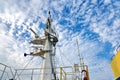 Ship structures, masts, antennas, funnel, ship wheelhouse against the blue sky and clouds.