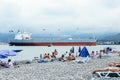 Ship tanker vessel on the beach. People rest on the seashore near the port. Batumi. Water pollution