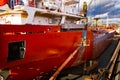 Ship undergoing maintenance in floating dock. Workers paint, repair vessel hull. Industrial, commercial shipyard Royalty Free Stock Photo