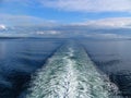 Large Ship Fan Trail on Sea Surface with clouds in blue sky Royalty Free Stock Photo