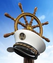 Ship wheel and captain hat against blue sky background. 3D illustration