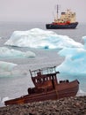 Ship wreck on Arctic coast with icebergs and icebreaker Royalty Free Stock Photo