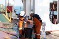 ship's crew working onboad ship carrying a heavy bucket on deck