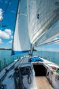 Ship yachts with white sails in the open sea with islands in the background. View from the sailing boat deck who is Royalty Free Stock Photo