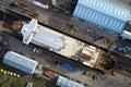 Shipbuilding construction ship in dry dock aerial view at shipyard harbour with scaffold