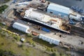 Shipbuilding construction ship in dry dock aerial view at shipyard harbour with scaffold