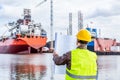 Shipbuilding engineer checking documents at the dock side in a port.