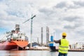 Shipbuilding engineer checking documents at the dock side in a port.