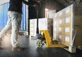 Shipment, Delivery, Cargo export Worker unloading heavy pallet goods, his using hand pallet jack loading into container truck. Royalty Free Stock Photo